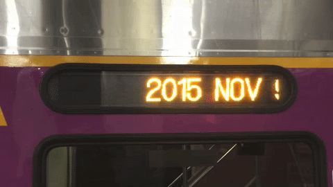 An animated image where the message '2015 NOV 97 86::3PM' scrolls across a train's LED display